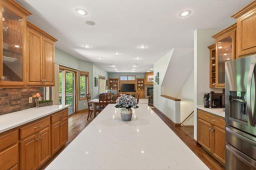 Chef's kitchen features large center island with counter seating, stainless steel appliances, a walk-in pantry and quartz countertops