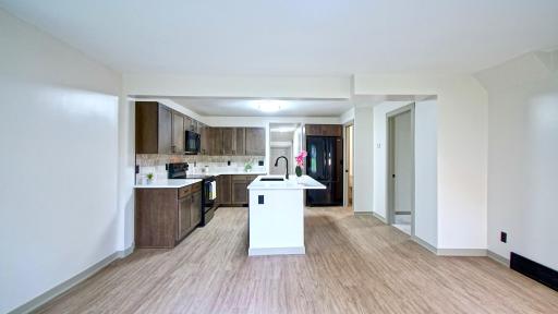 View of updated kitchen from the living room. First door on the right leads to primary bedroom.