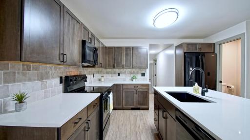 The kitchen has numerous updates including new quartz countertops, new range, dishwasher, microwave and refrigerator. New tile backsplash as well!