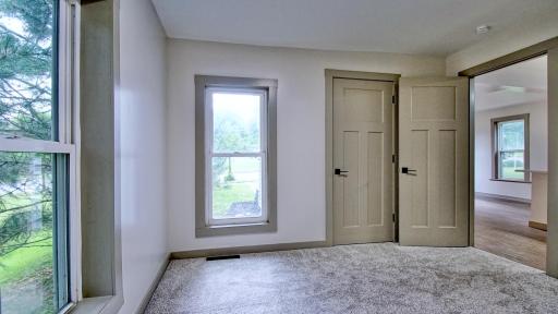 Interior view of primary bedroom. Spacious closet under staircase to upper level.