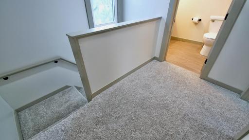 Upper level loft area outside full bath and upper level bedroom.