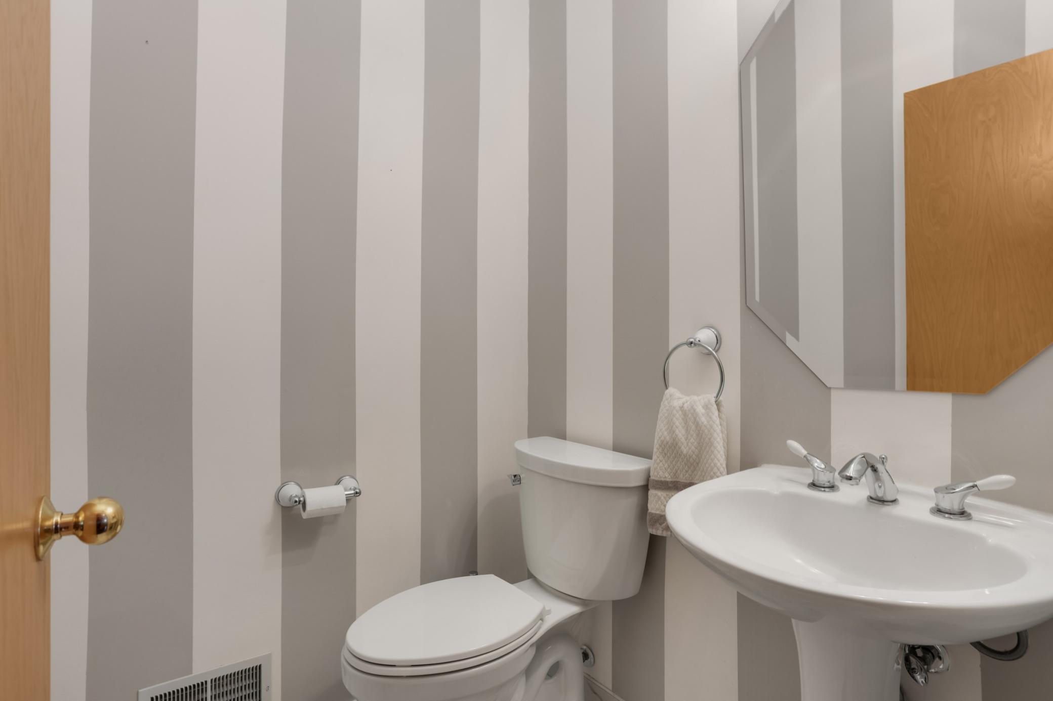 Main floor half bath has decorative painting and professionally tiled floors.