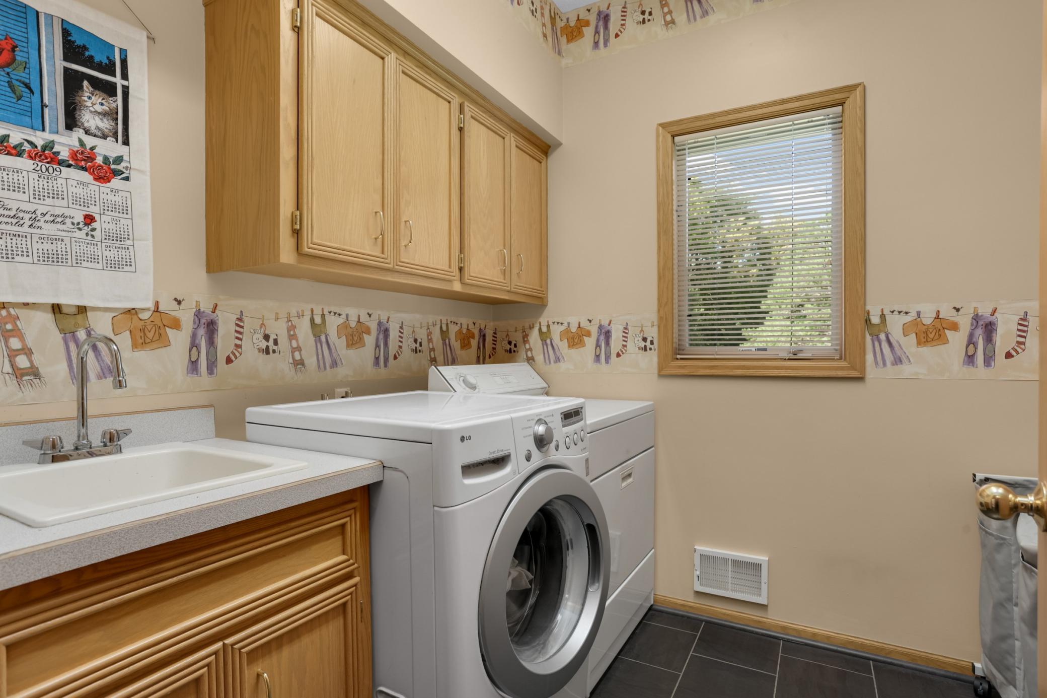 Spacious laundry room is conveniently located on the main level with handy utility sink as well.