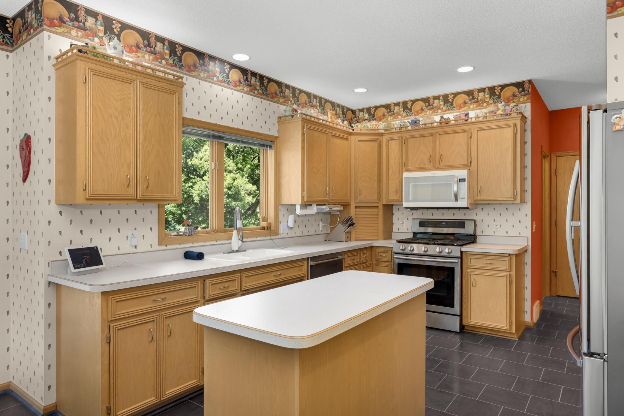 Newer appliances and plenty of counter space with a window looking over the backyard.