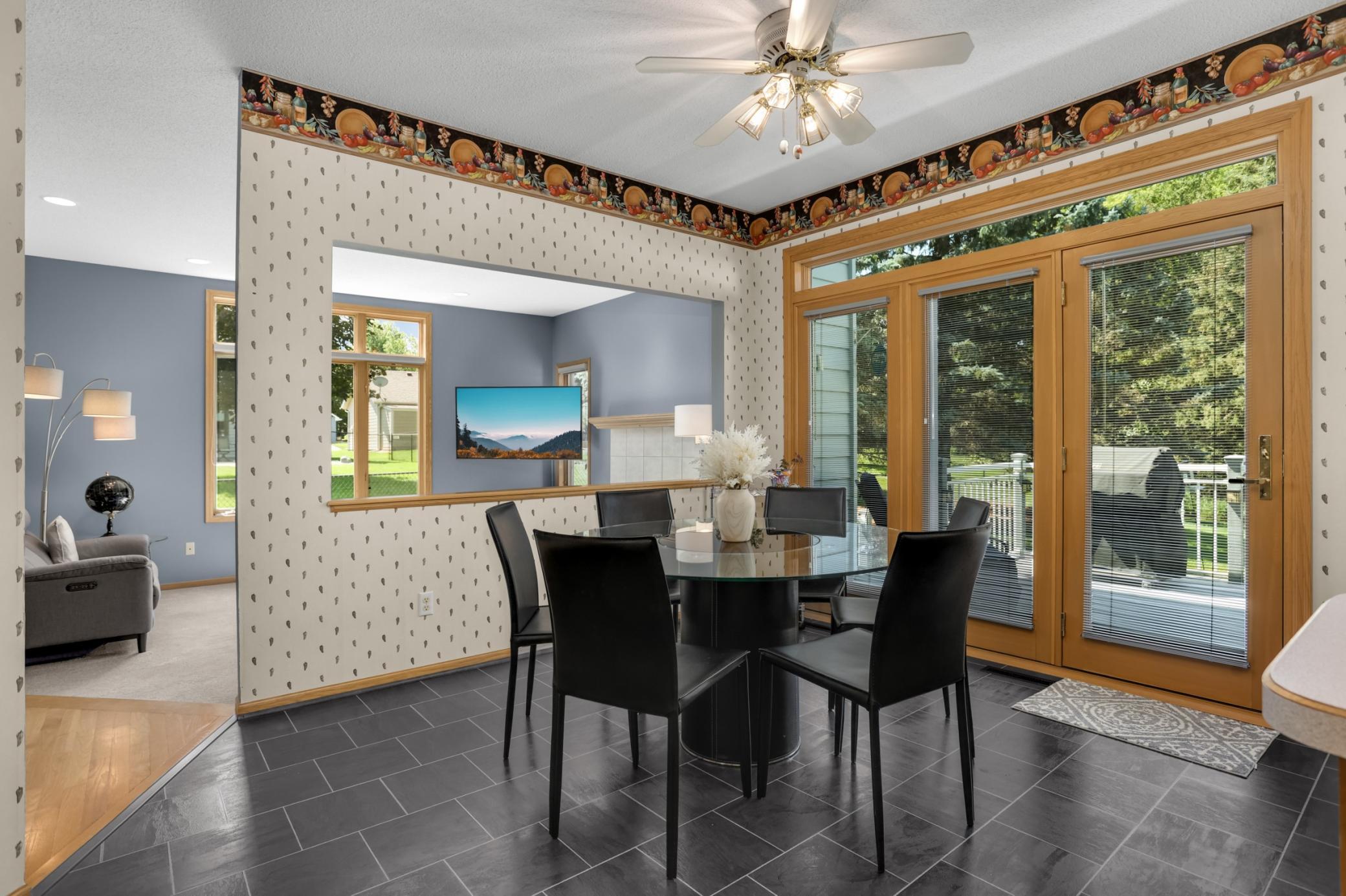 The informal dining area has a wall of windows. This three panel patio door system was recently replaced.
