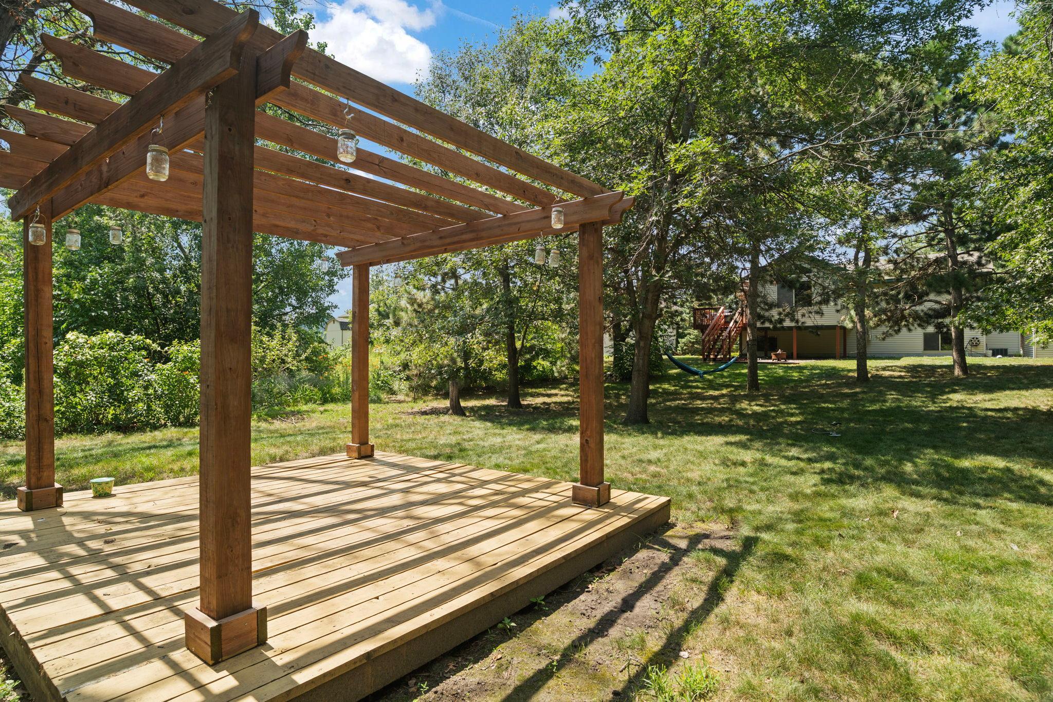 The backyard pergola overlooks the spacious, tree-filled yard and offers endless possibilities for outdoor enjoyment.