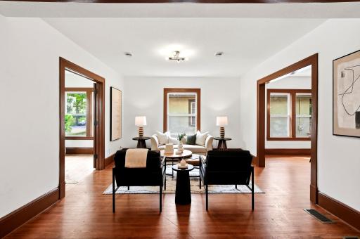 This inviting living room offers beautiful natural light, refinished hardwood floors, new windows, and the peace of mind of a new HVAC system, new ductwork, and a completely updated electrical system.