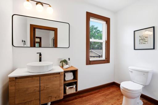 The main-floor half bath has been completely remodeled with stylish, modern finishes, including a new vanity, updated lighting, new flooring, contemporary fixtures, and fresh paint. Thoughtfully redesigned to complement the home's high-end renovation