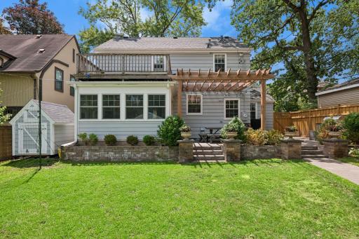 Large, fully fenced backyard features a new paver patio and walkway, pergola, and built-in grill with stone countertops.