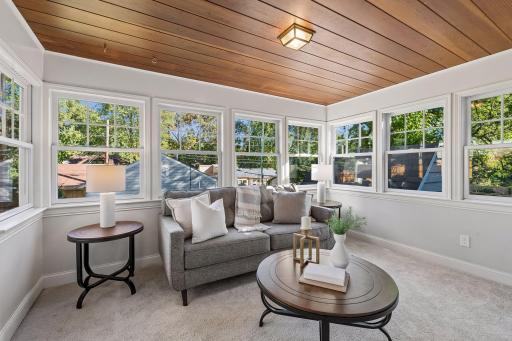 Bright, airy sunroom overlooking backyard walks out to patio.
