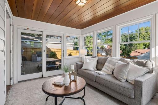Bright, airy sunroom overlooking backyard walks out to patio.