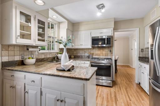 Eat-in kitchen with peninsula, granite countertops & stainless appliances.