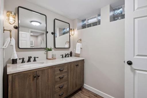 Basement full bath features dual vanities.
