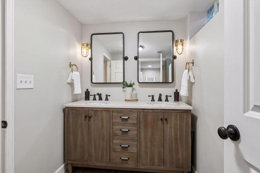 Basement full bath features dual vanities.