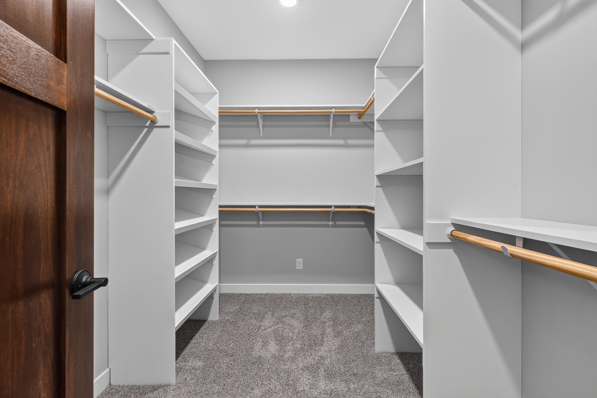 Large walk in closet in the primary bedroom featuring custom shelving