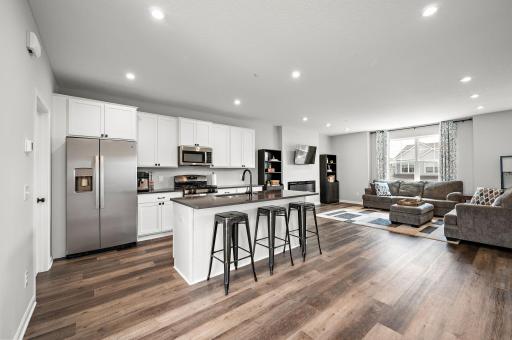 Gorgeous, expansive kitchen with quartz countertops, a large center island, gas range and tile backsplash. - Open Main Floor Plam!