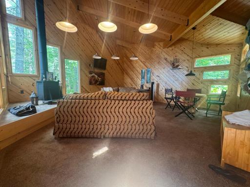 The spacious second family room offers a cozy retreat designed for relaxed cabin living. Centered around a classic Franklin stove, the space radiates warmth and charm, making it an ideal spot for gathering after a day outdoors