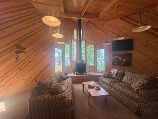 Natural wood accents, comfortable seating, and wide windows that frame the surrounding trees create an inviting atmosphere that feels both rustic and refined