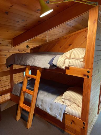 Each bunk features sturdy craftsmanship, cozy bedding, and individual reading lights, making it an ideal space for kids, guests, or group getaways.