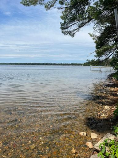 The cabin enjoys access to a lake renowned for its exceptional water clarity, where the shoreline reveals shimmering, glass-like water that lets you see straight to the sandy bottom.
