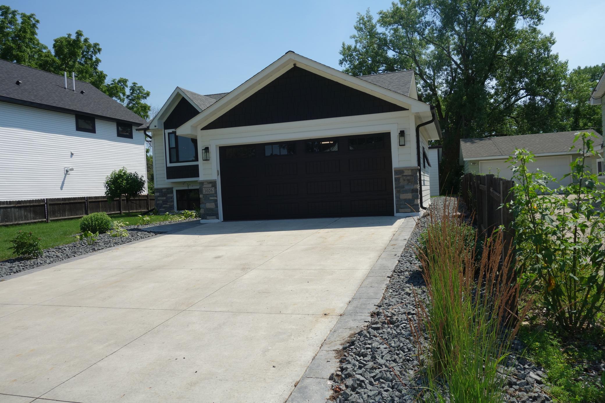 Cement driveway with accented sides and nice landscaping.