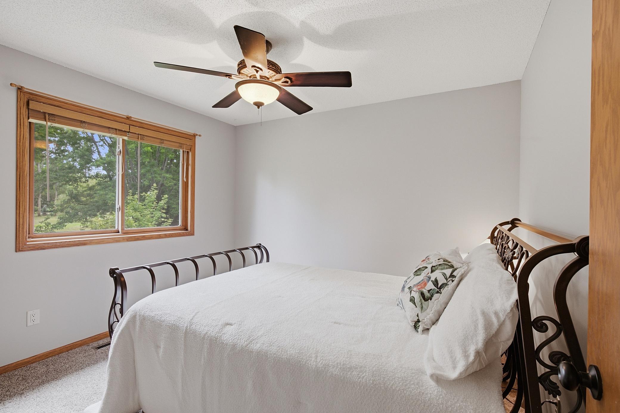 Second beroom on the upper level boast a ceiling fan, large closet, and peaceful views of the back of the property.