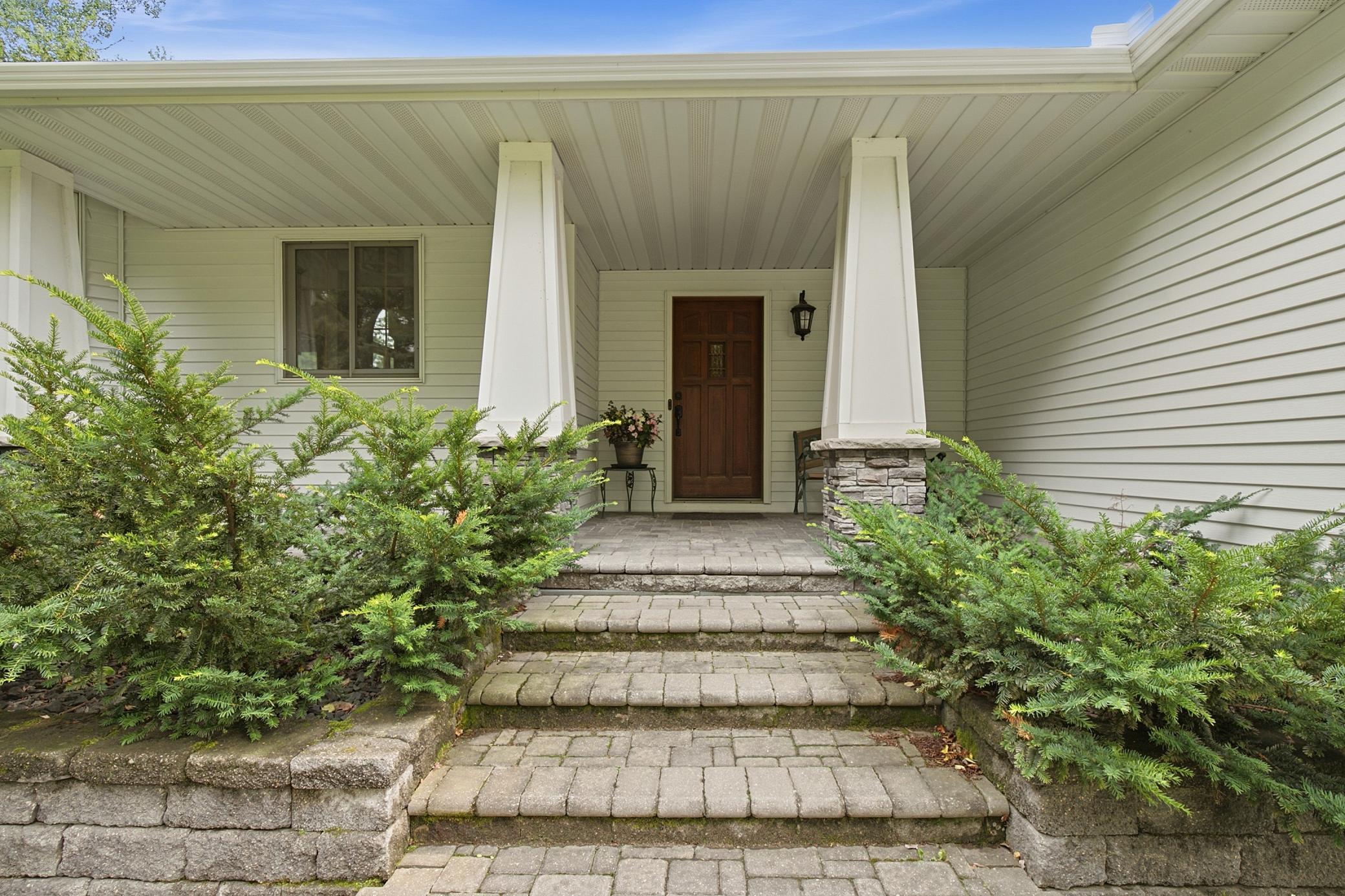 Stunning stone front patio is charming and covered.