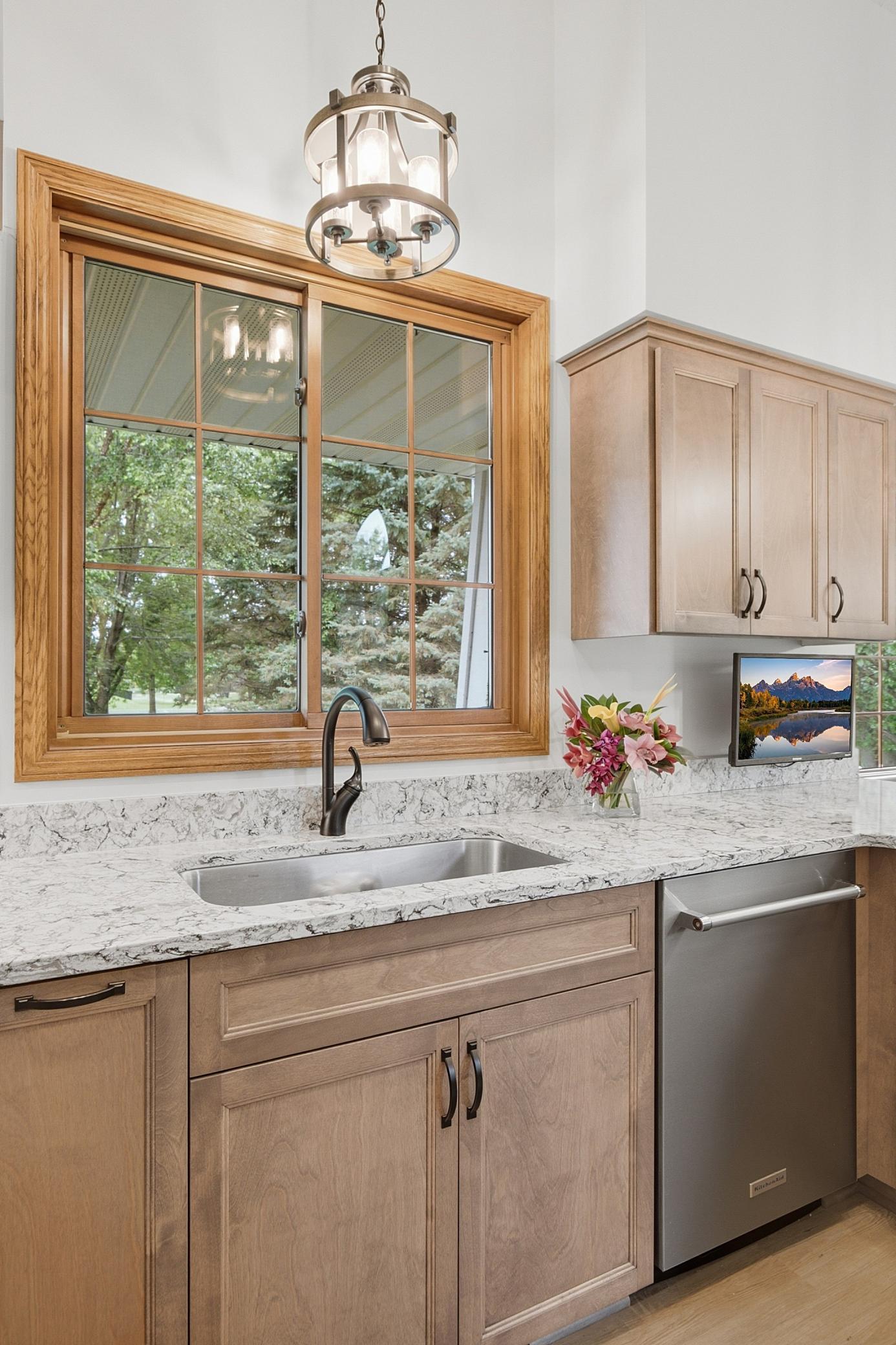 The undermounted and oversized kitchen sink sits just below a large window out the front of the home.