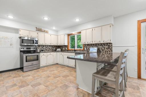 Stainless steel appliances, lots of counter space, large island, tile backsplash, and a kitchen window overlooking the backyard!