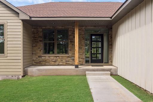 Front porch; this photo has been digitally enhanced. The grass shown in this image is not present at the property and is for visualization purposes only.