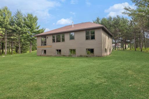 Back of house; this photo has been digitally enhanced. The grass shown in this image is not present at the property and is for visualization purposes only.