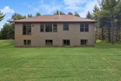 Back of house; this photo has been digitally enhanced. The grass shown in this image is not present at the property and is for visualization purposes only.