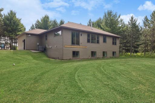 Back of house; this photo has been digitally enhanced. The grass shown in this image is not present at the property and is for visualization purposes only.