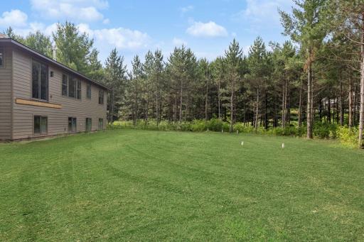 Back of house; this photo has been digitally enhanced. The grass shown in this image is not present at the property and is for visualization purposes only.