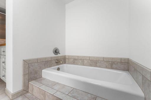Tub in upper level full bath nicely lit by skylight