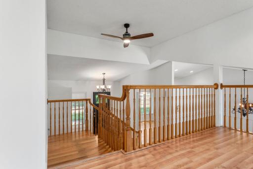 View from upper level living room to foyer and kitchen