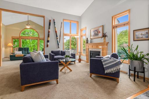 Sun-filled living room with expansive windows and gas fireplace.