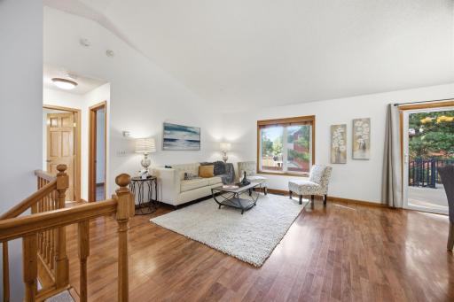 The living room is a great space for friends to gather with plenty of natural light from the large window and sliding door. The neutral paint color and vaulted ceilings add to the open feel.