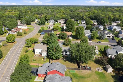 Home from aerial photo showing the large fenced in yard and pine trees (second house from the corner).