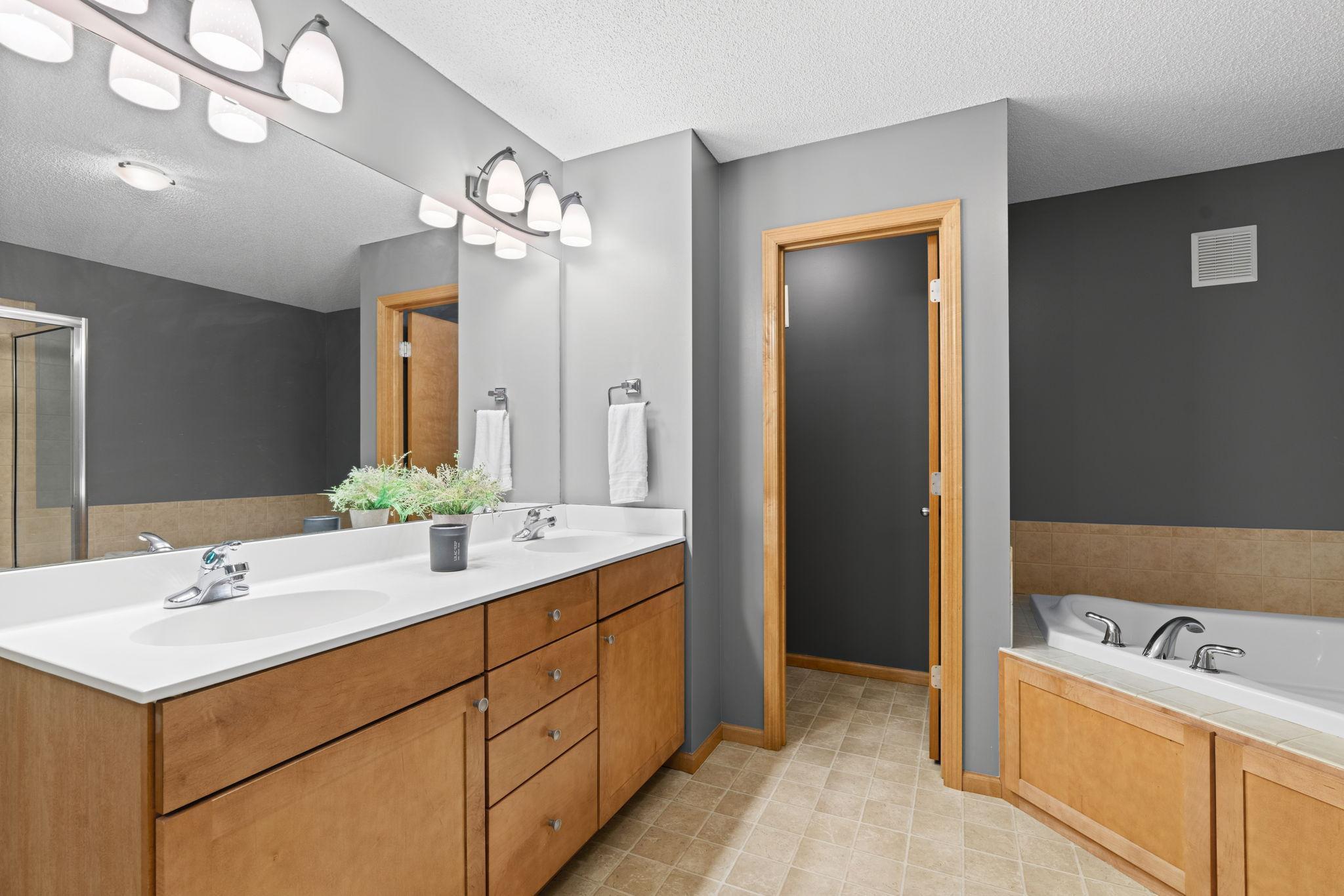 primary en suite with closed door to bathroom, jacuzzi tub and walk-in shower