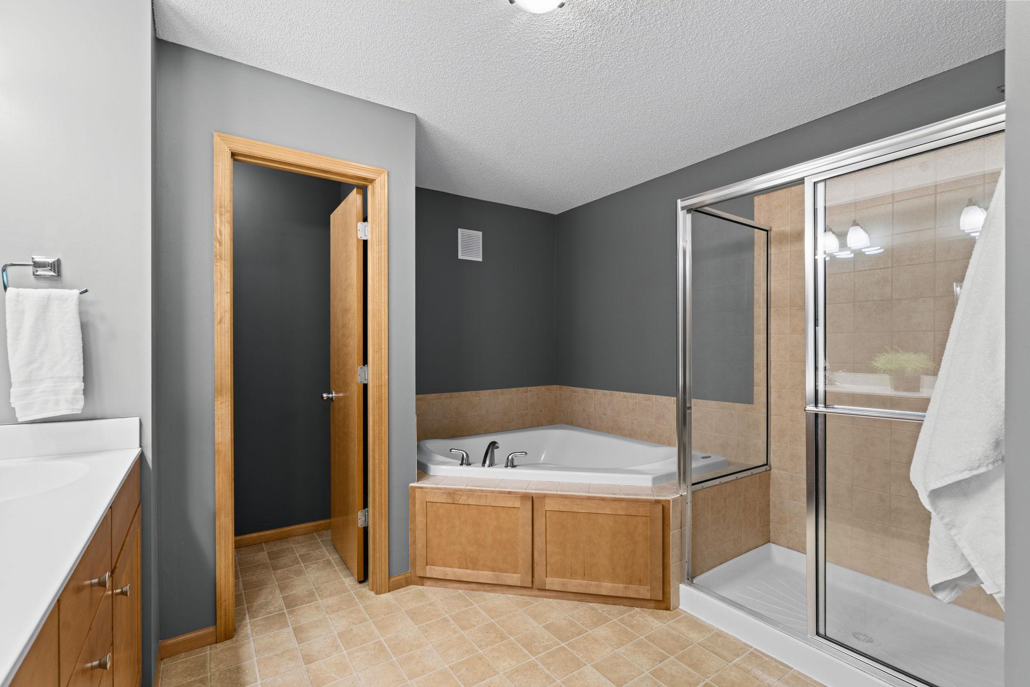 primary en suite with closed door to bathroom, jacuzzi tub and walk-in shower
