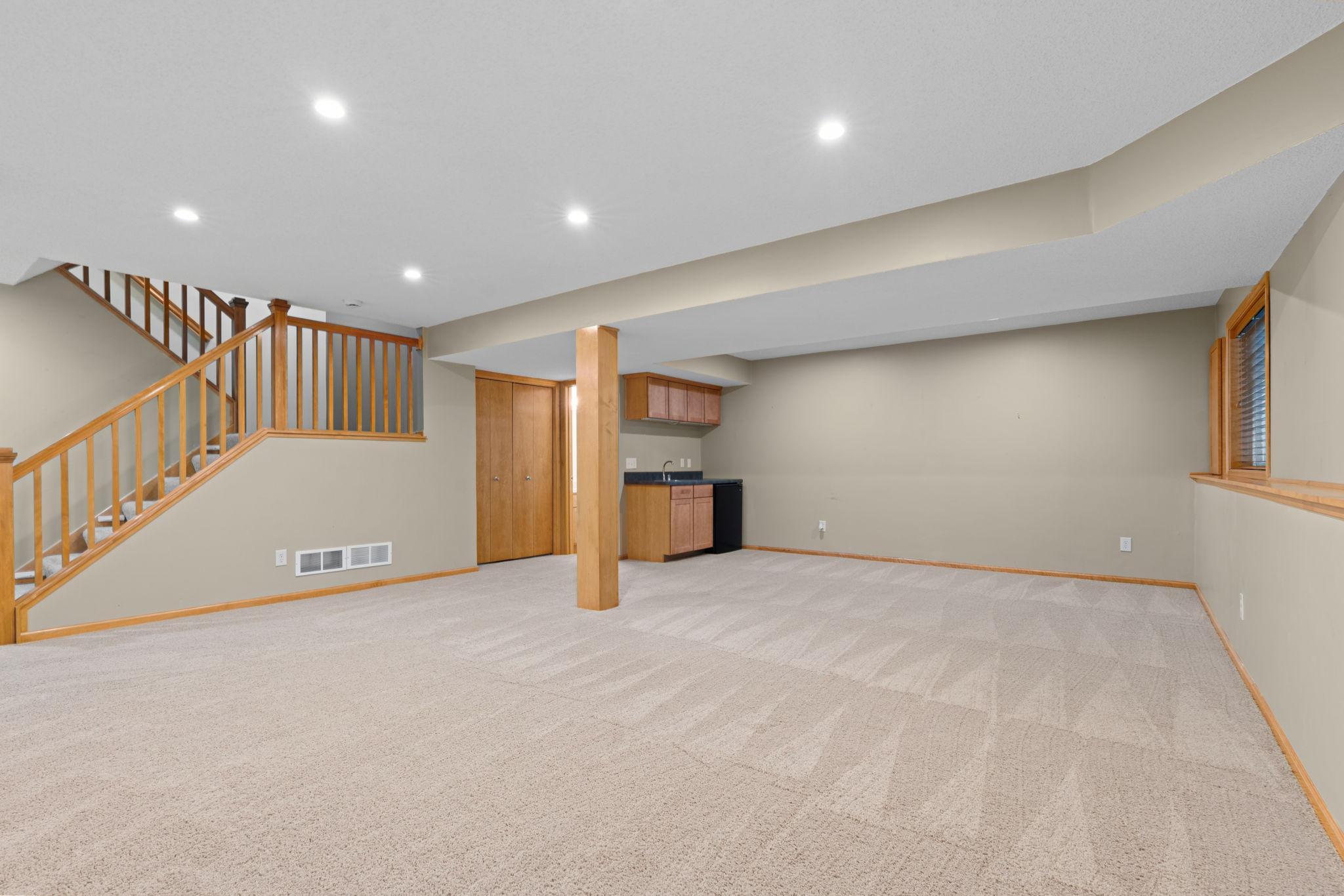 large basement with kitchenette and bathroom