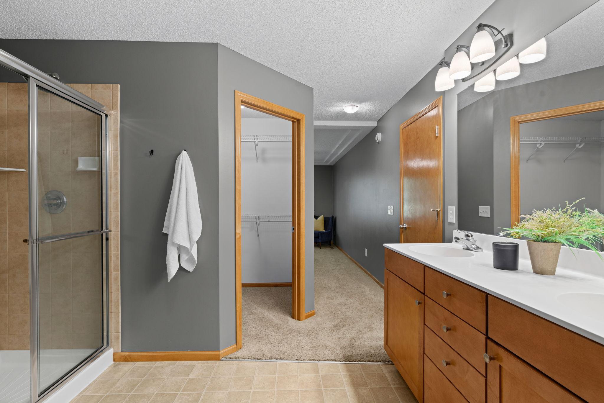 standing in primary en suite looking onto primary walk-in closet and bedroom area