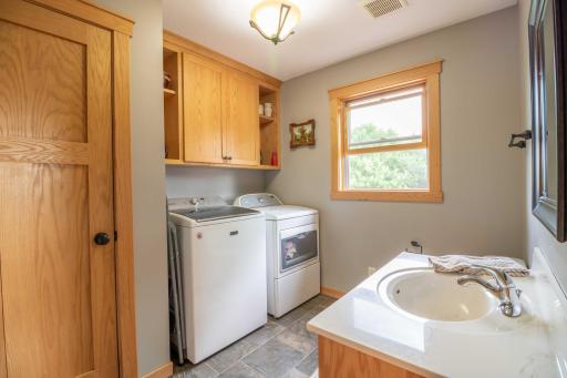 Main floor laundry room with sink and storage