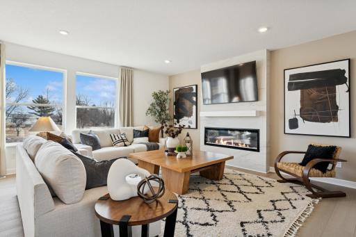 (Photo of a decorated model, actual homes finishes will vary) Accented by this stunning fireplace - the home's main level family space serves as an incredible addition to the open flow throughout the home.