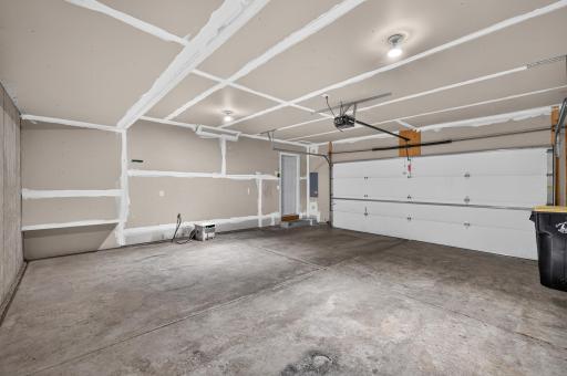 Spacious garage welcomes room for large vehicles and storage space