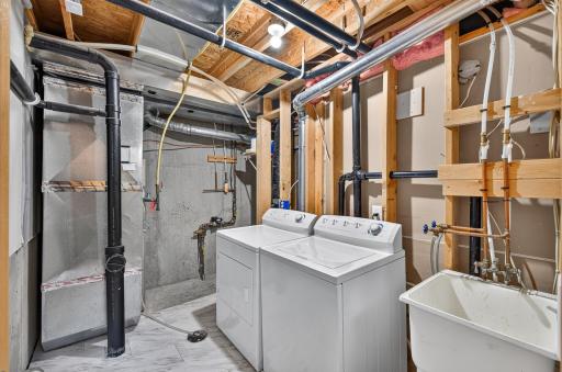 Mechanical room with a convenient laundry sink and newer water heater. Washer and Dryer included with sale.