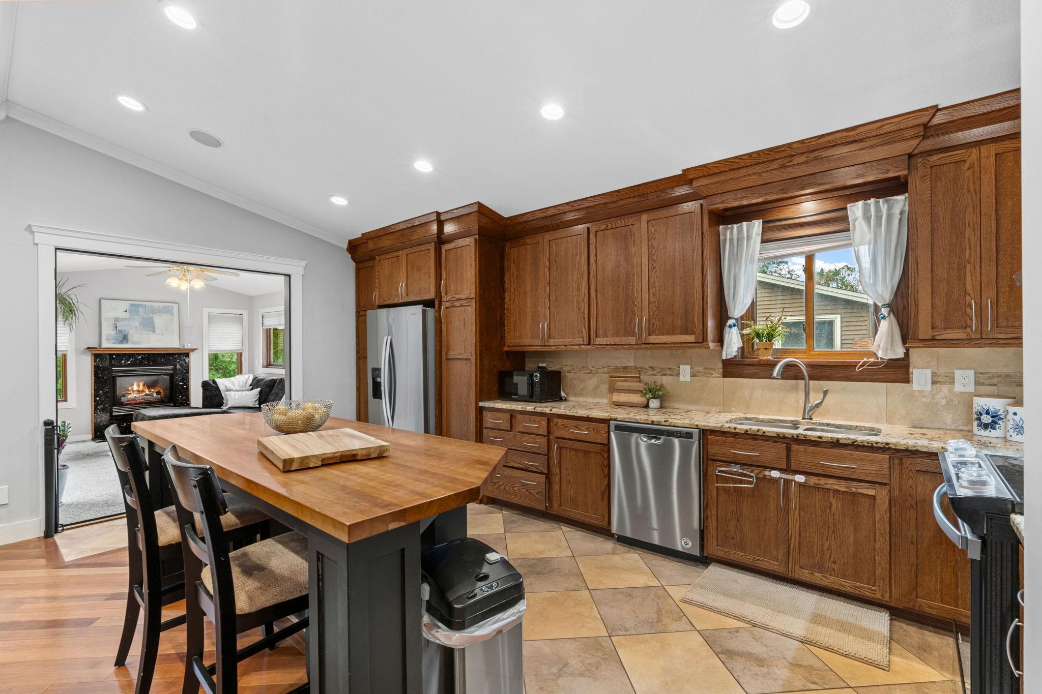 This kitchen is a cooks dream! Granite countertops + butcher block center island, stainless steel appliances, kitchen window, and an abundance of cabinet storage.