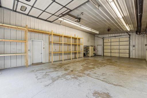 Large heated garage with shelving, holds 4 cars. Back door opens to loft and storage.