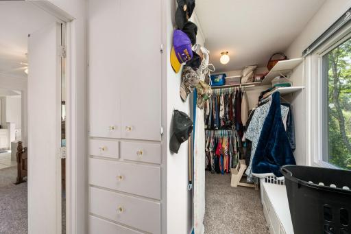 Large walk-in closet in primary bedroom w/ built-in drawers